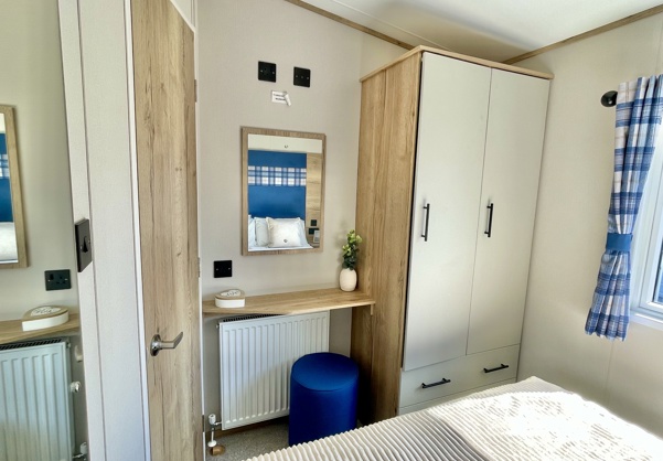Internal of a caravan master bedroom with storage and dressing area
