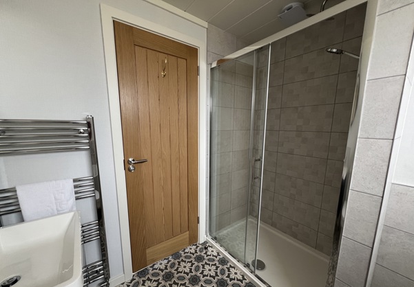 Large shower in main bathroom with stylish floor tiles