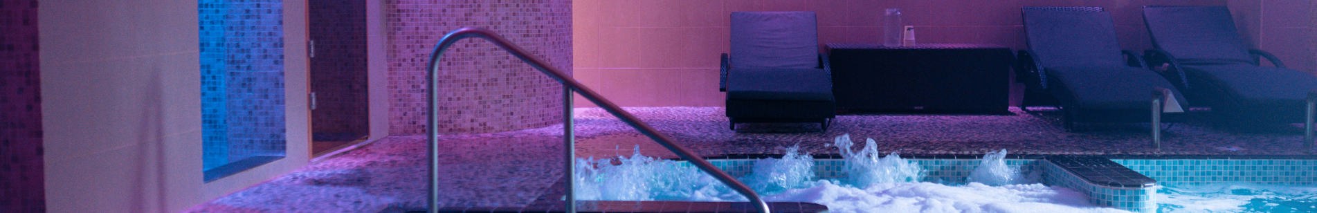A hydrotherapy pool with loungers and calm lights