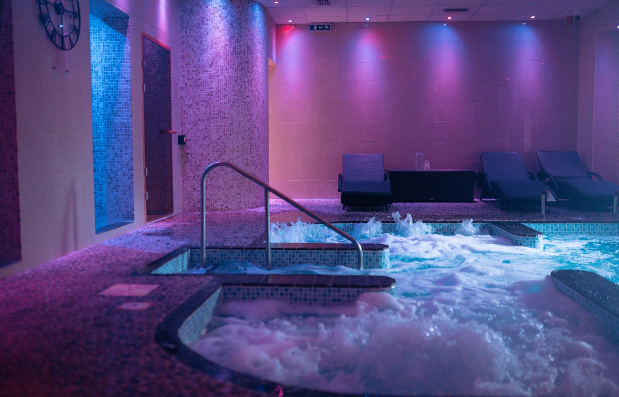 A hydrotherapy pool with loungers and calm lights