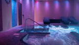 A hydrotherapy pool with loungers and calm lights
