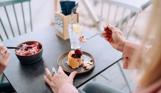 Two women sat at a table in the outside seating area of a restaurant with desserts