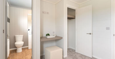 Internal of a luxury lodge master bedroom with ensuite, dressing area and storage