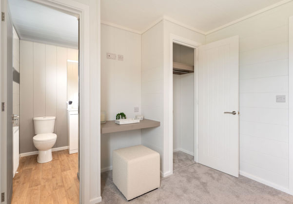 Internal of a luxury lodge master bedroom with ensuite, dressing area and storage