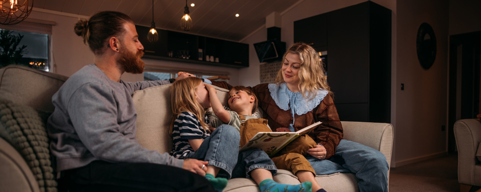 Family reading time on sofa before bedtime