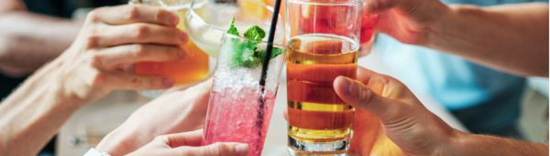 A group of people toasting a selection of different cocktails and drinks