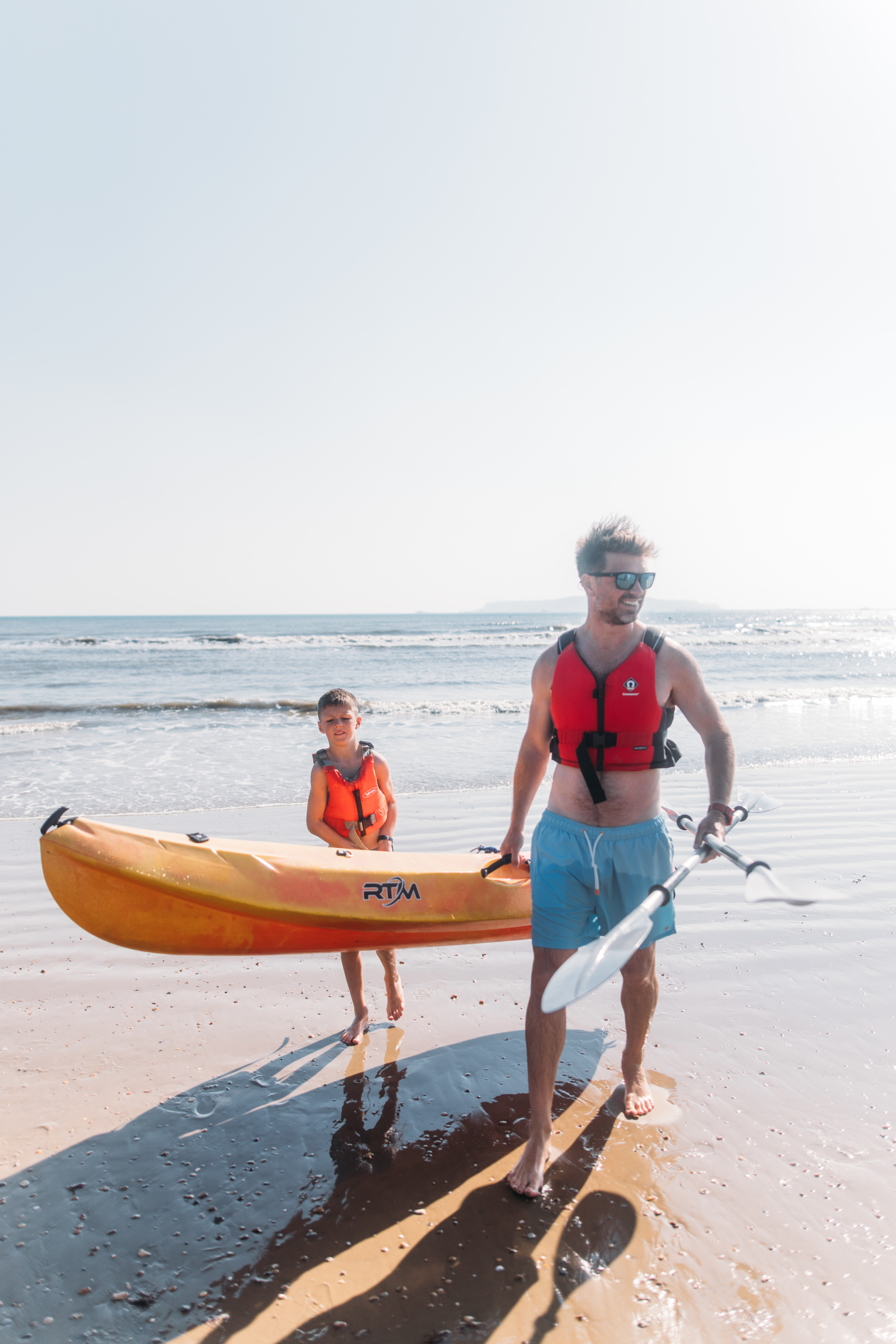 Father and son kayaking in bowleaze cove