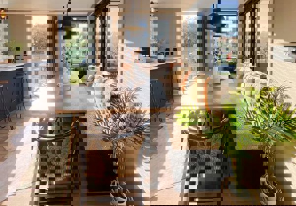 Large dining table with bench seating opposite open plan kitchen