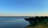 Fleet Lagoon at sunset with calm blue water and Chesil Beach in the background