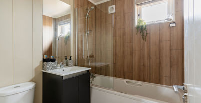 Internal of a luxury lodge bathroom with sink, toilet and shower over bath