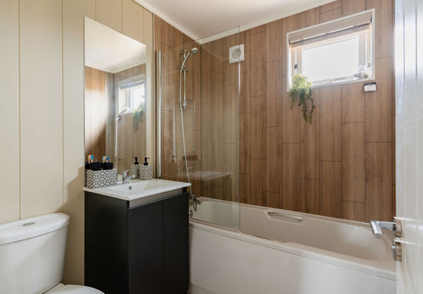 Internal of a luxury lodge bathroom with sink, toilet and shower over bath