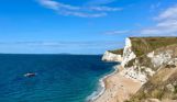 The view of Durdle Door Beach and beyond on a striking sunny, blue sky day with blue water