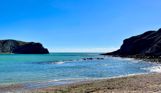 The view from Lulworth Cove out to sea on a striking sunny, blue sky day with blue water