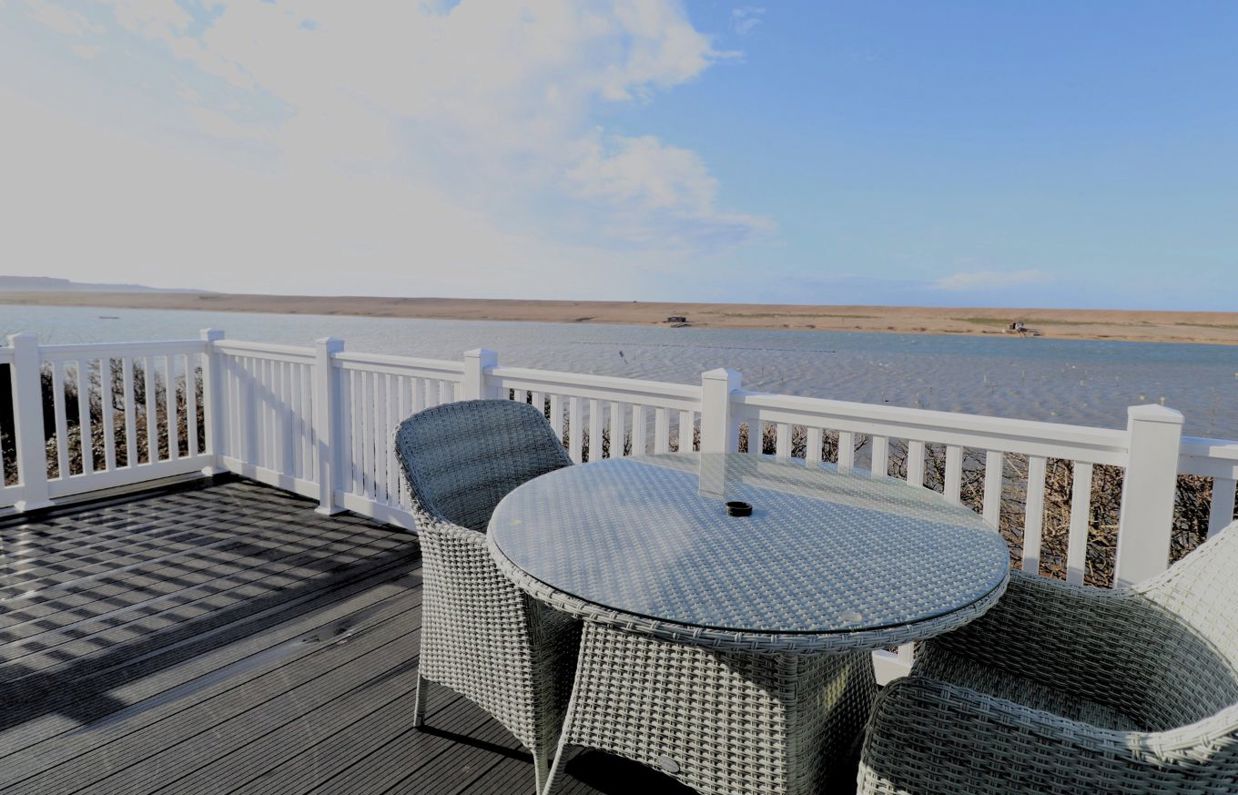 External of a caravan decking with outdoor furniture and seaviews