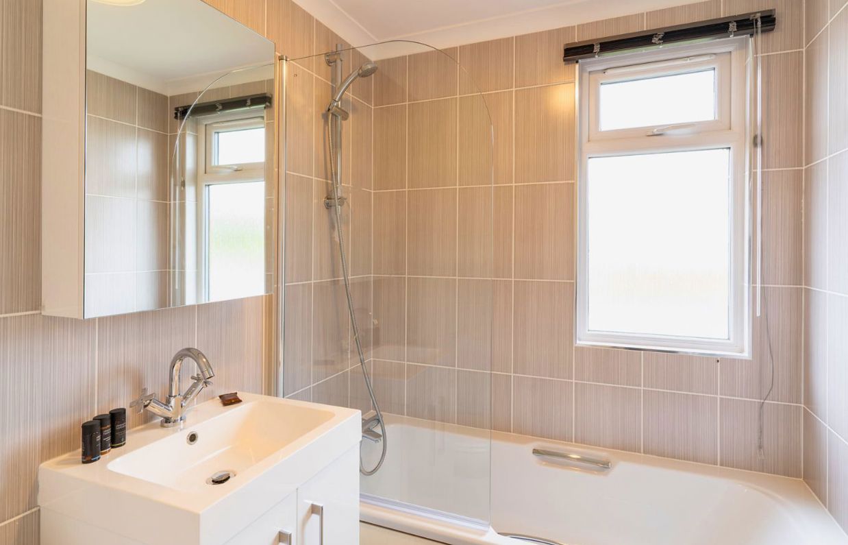 Internal of a lodge bathroom with shower over bath and sink