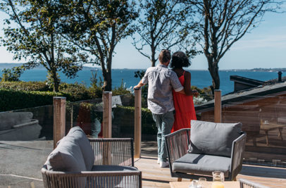 A couple cuddle and admire the view out to the sea and Portland from their decking