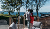A couple cuddle and admire the view out to the sea and Portland from their decking