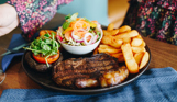 A steak and chips dish with salad