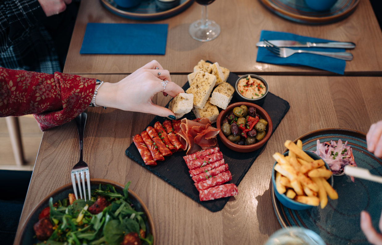 A charcuterie board and other dishes on a table at Drift Bar & Grill