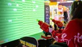 A girl playing space invaders game looking up at the screen