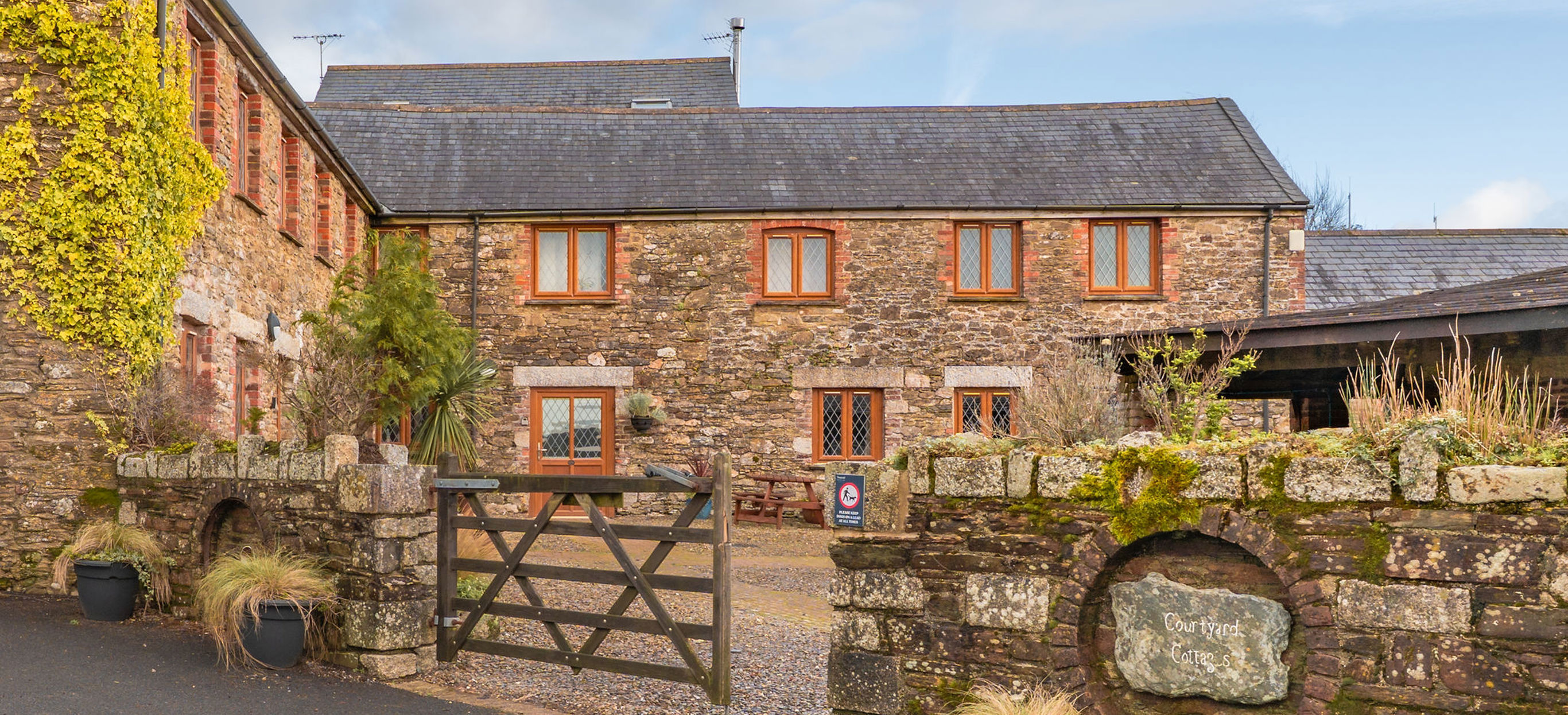 External of a cottage courtyard area with outdoor benches and flowers