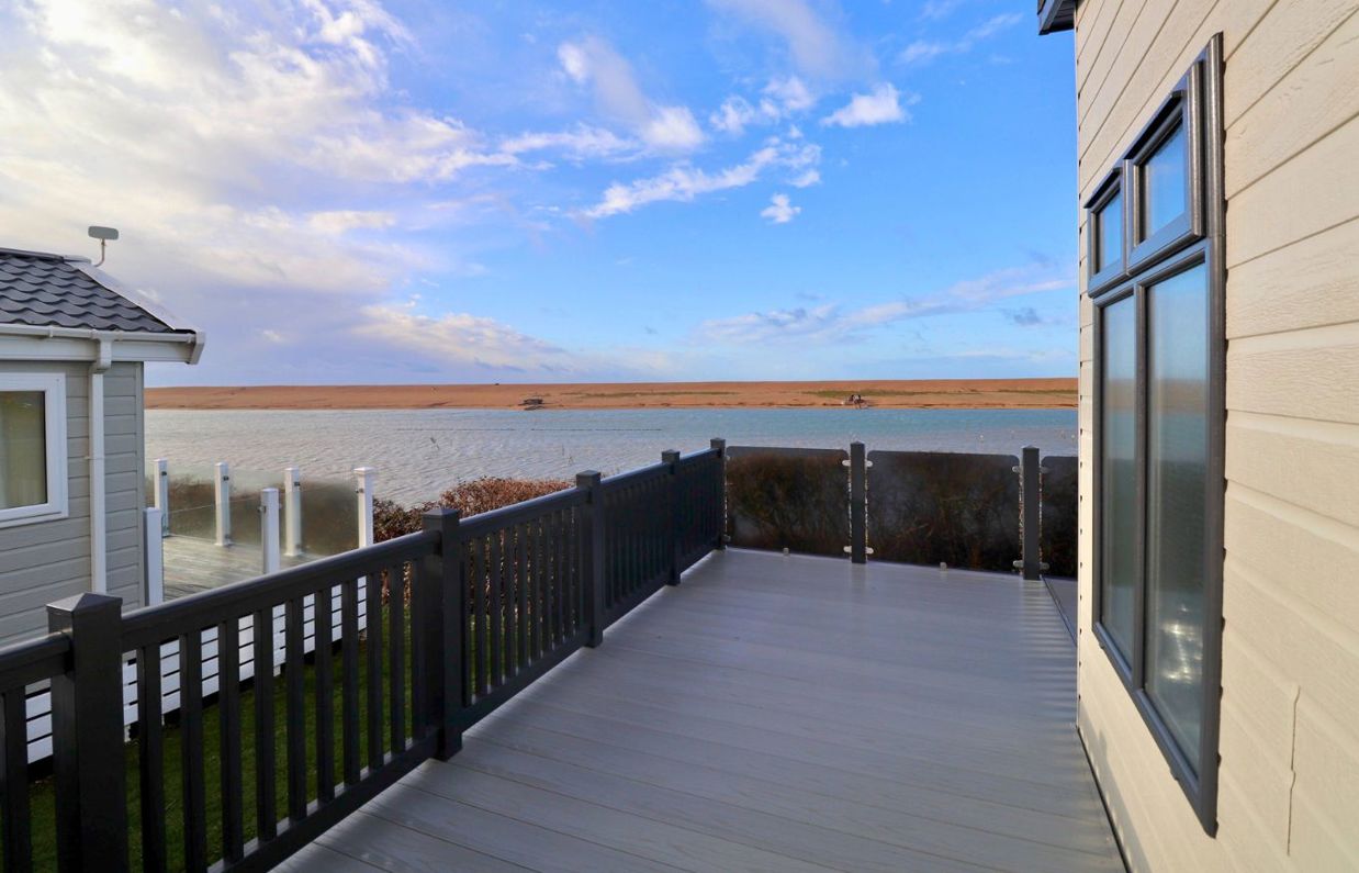 External of a caravan on pitch with decking and seaviews