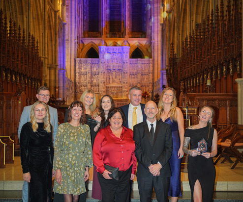 A group of people stood on steps within a cathedral with a dramatic backdrop