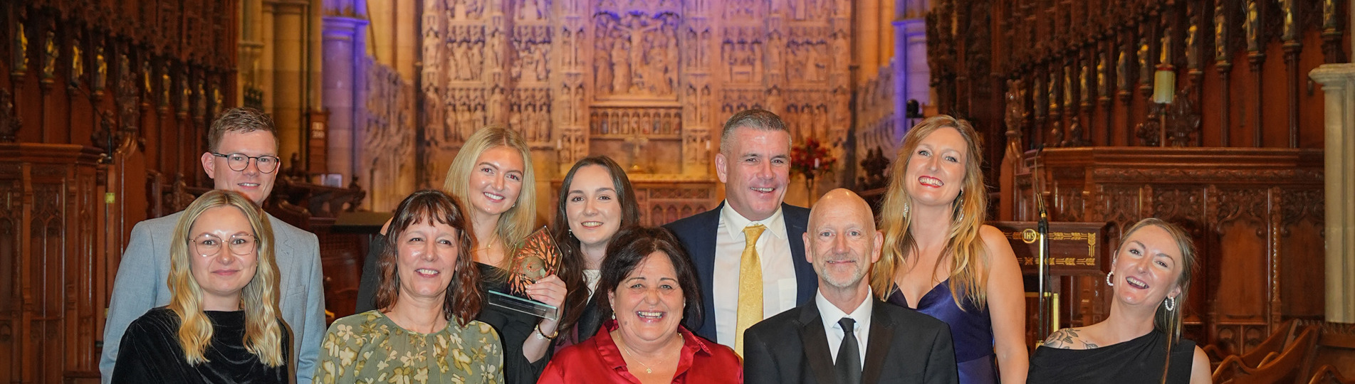 A group of people stood on steps within a cathedral with a dramatic backdrop