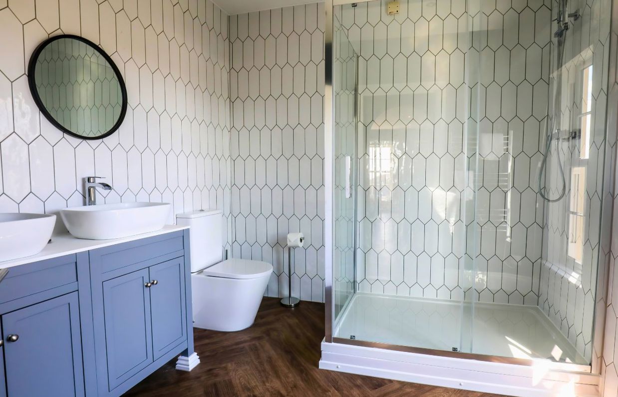 Internal of a manor house ensuite bathroom with shower, toilet and his & hers sinks