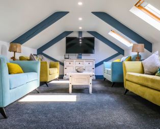 Internal of a cottage lounge with four sofas and a wall-mounted tv