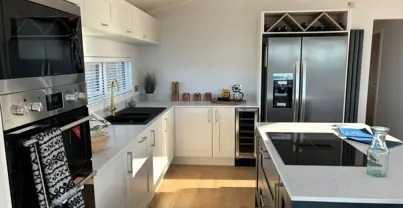 Light modern kitchen with island and large standalone fridge freezer