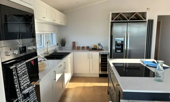 Light modern kitchen with island and large standalone fridge freezer