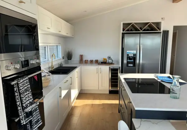 Light modern kitchen with island and large standalone fridge freezer