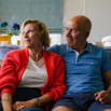A couple sat talking together on a sofa