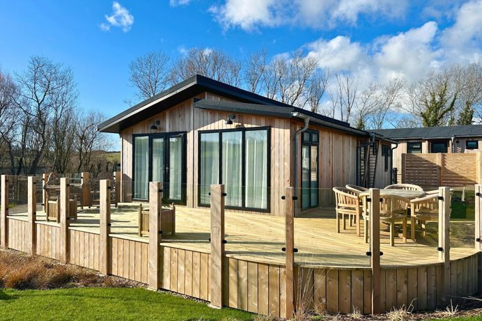 External of a luxury lodge decking with outdoor furniture