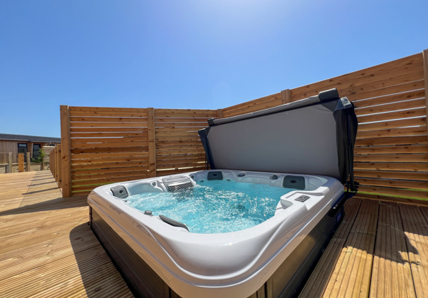 External of a luxury lodge with decking and hot tub