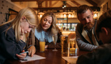 A couple with their two sons sat at a table in Stargazy Bar & Grill looking at a worksheet with drinks on the table