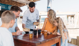 A chef serving a family of four street food at an outside table