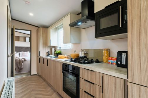 Internal of a caravan open plan kitchen adjacent to bedroom