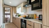 Internal of a caravan open plan kitchen adjacent to bedroom