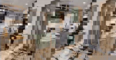 Contemporary kitchen with sage cupboards and black cooking appliances