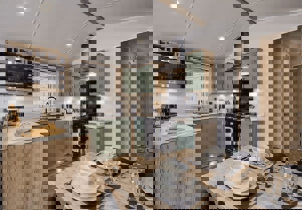 Contemporary kitchen with sage cupboards and black cooking appliances