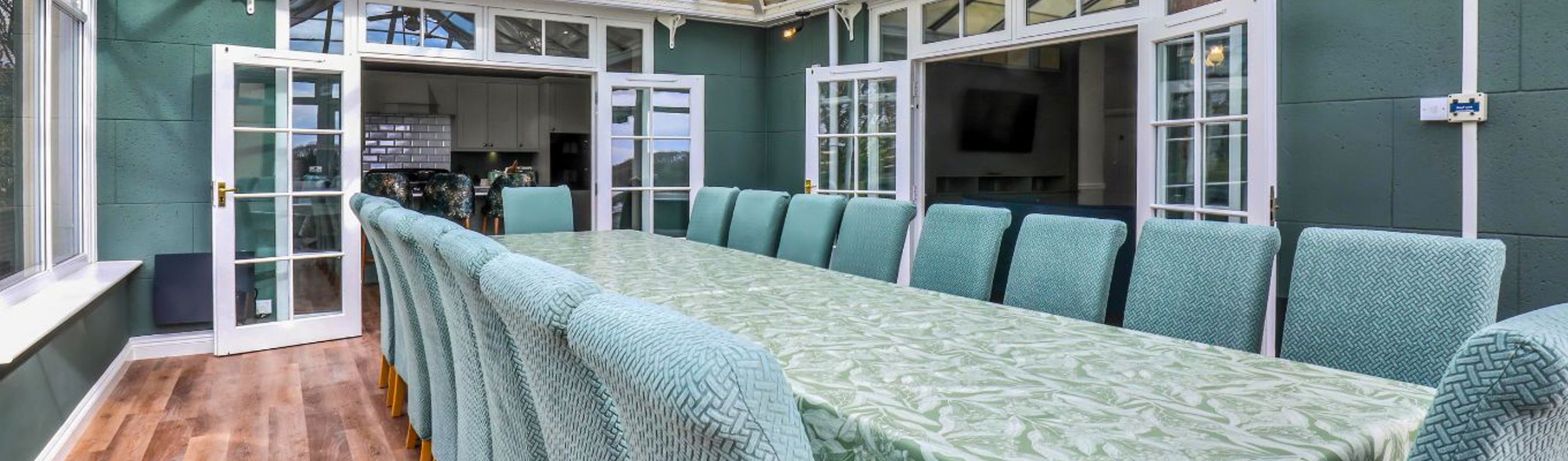 Internal of a manor house conservatory dining area with table and chairs for 18 guests