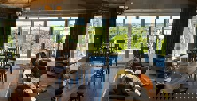 View outside to valley beyond from the living area showing open plan layout in modern country style