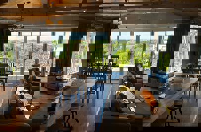 View outside to valley beyond from the living area showing open plan layout in modern country style