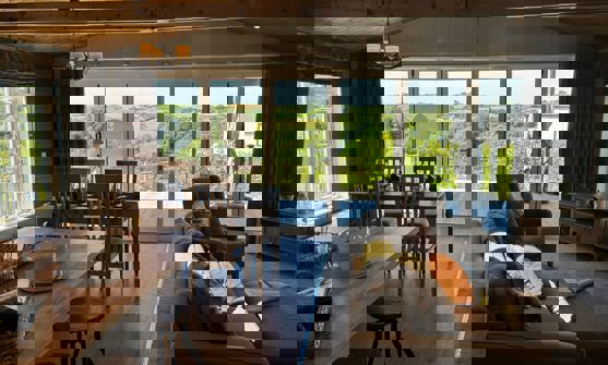 View outside to valley beyond from the living area showing open plan layout in modern country style