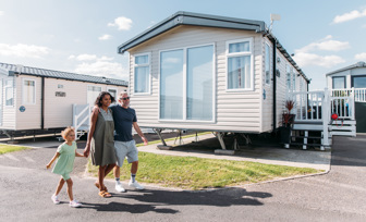Family walking down lane surrounded by caravans