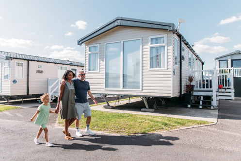Family walking down lane surrounded by caravans