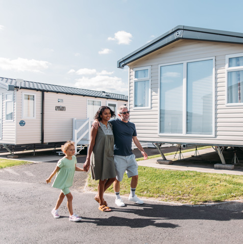 Family walking down lane surrounded by caravans