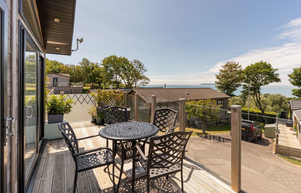 External of a lodge decking with outdoor furniture and sea views